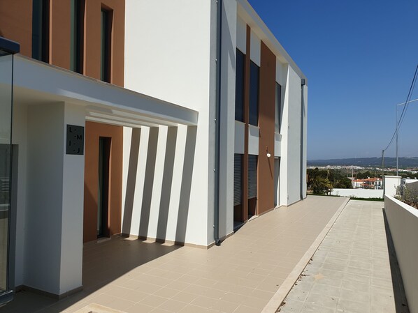 A modern building with a flat roof, large windows, and a clear view of the surrounding area. - Nabaía, ground floor new apartment 7-9 pers. with sea view in Salir do Porto (Salir do Porto)