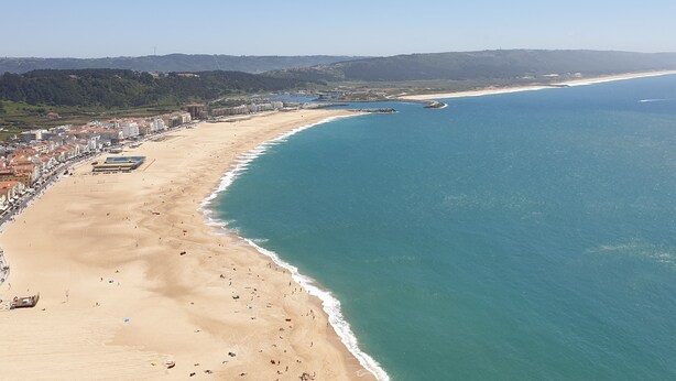 A coastal cityscape with a wide sandy beach, a clear blue sea, and a backdrop of hills. - Nabaía, ground floor new apartment 7-9 pers. with sea view in Salir do Porto (Salir do Porto)