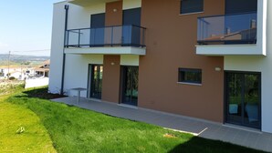 A modern two-story residential building with a flat roof, large windows, and a balcony on the upper floor. - Nabaía, ground floor new apartment 7-9 pers. with sea view in Salir do Porto (Salir do Porto)