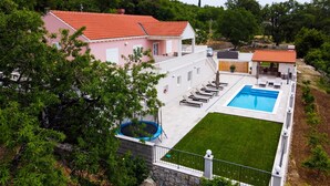 A house with a swimming pool, a covered patio, and a lush garden. - Villa Dragic (Konavle)