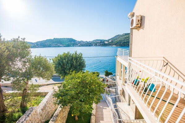 A balcony with a view of a lake and hills.