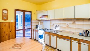 Une cuisine avec des meubles de rangement en bois, une cuisinière, un four à micro-ondes et un évier.