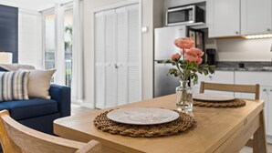 A dining table with a plate, a vase with flowers, and a woven placemat.