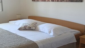 Ein Schlafzimmer mit Bett, Nachttisch, Wandklimaanlage und einem Gemälde.