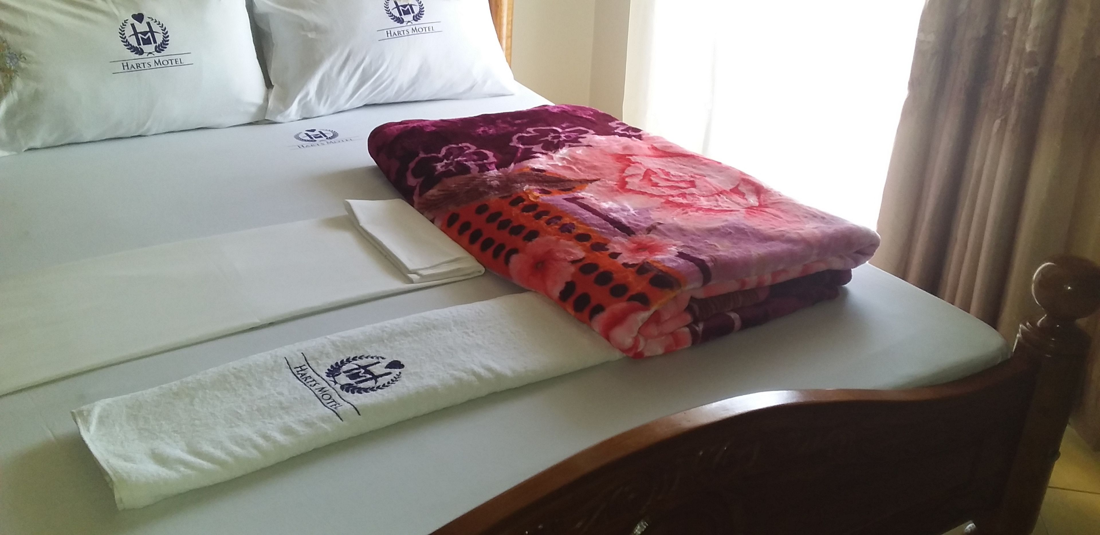 A neatly made bed with a floral-patterned blanket and a matching pillow.