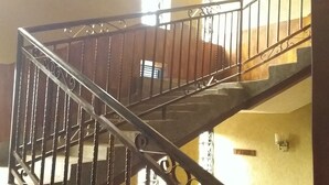 Un escalier avec des rampes en métal et une main courante en bois.