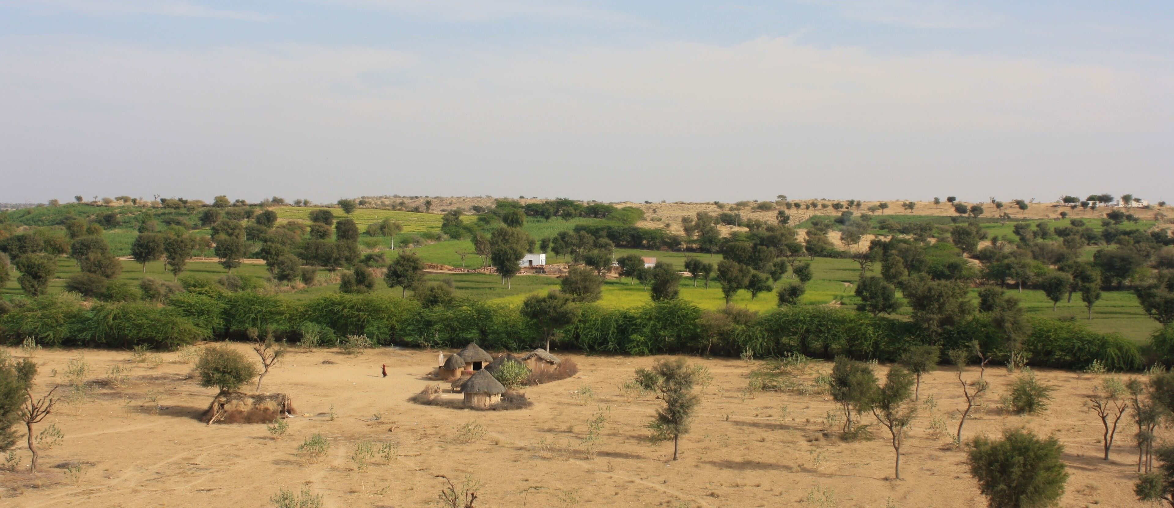 A rural landscape with scattered houses and greenery.
