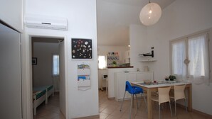 A compact kitchen with a dining area, a small kitchenette, and a child's room. - Ville La Tana - Paola (Lignano Sabbiadoro)