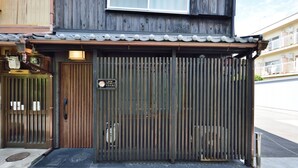A traditional Japanese-style building with a wooden exterior, a tiled roof, and a metal gate. - Shiki Tofukuji (Kyoto)