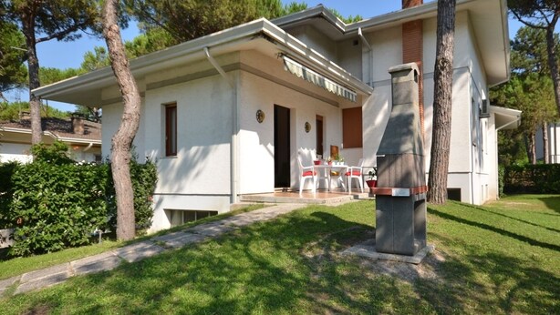 A two-story house with a patio area featuring outdoor furniture. - Ville Missana (Lignano Sabbiadoro)
