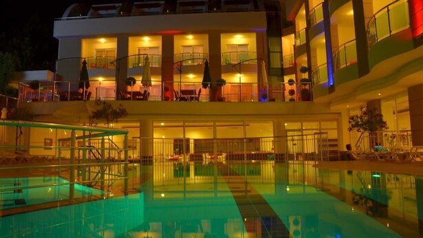 A multi-story hotel with a swimming pool, balconies, and outdoor seating areas. - Life Elite Hotel (Manavgat)