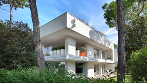 A modern two-story house with a flat roof, large windows, and a balcony. - Ville Summer (Lignano Sabbiadoro)
