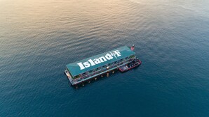 An aerial view of a floating hotel with a large deck and multiple levels. - Island.F Jeju (Seogwipo)
