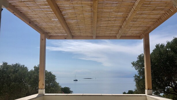 Un espacio al aire libre cubierto con vistas al mar y barcos a lo lejos.