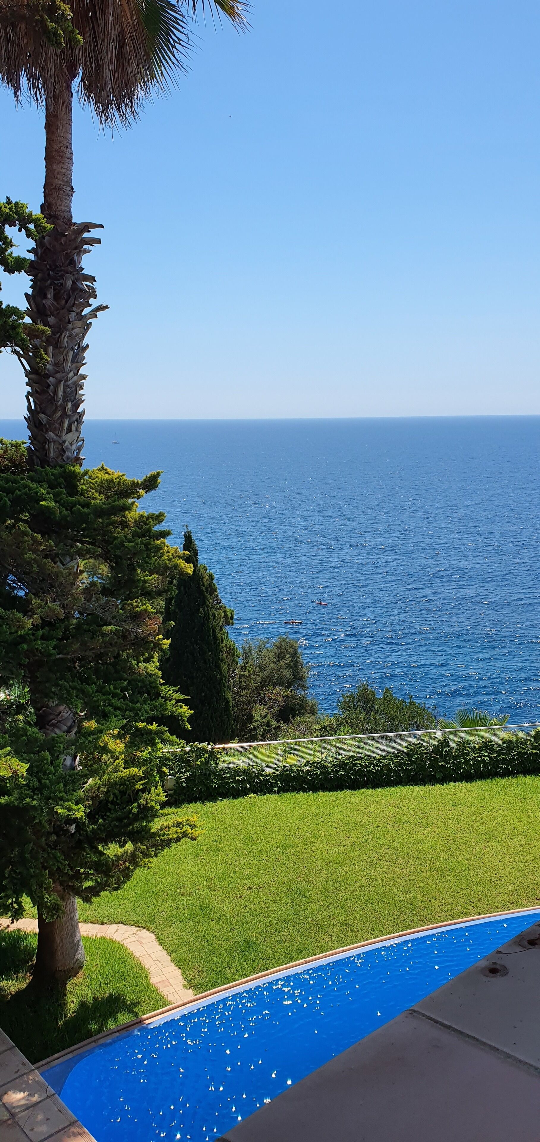 Una piscina con vistas al mar y un cielo despejado.