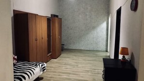 A room with a zebra-patterned bed, wooden wardrobe, and a desk with a lamp. - Apartment on Tsamebuli Ave (Tbilisi)