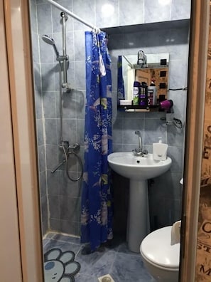A bathroom with a shower, a sink, and a toilet. - Apartment on Tsamebuli Ave (Tbilisi)