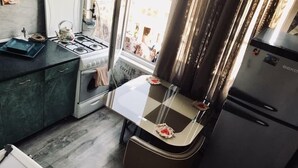 A compact kitchen with a gas stove, oven, and a refrigerator. - Apartment on Tsamebuli Ave (Tbilisi)