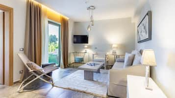 Una sala de estar moderna con un sofá, un sillón, una mesita de centro y un televisor montado en la pared.
