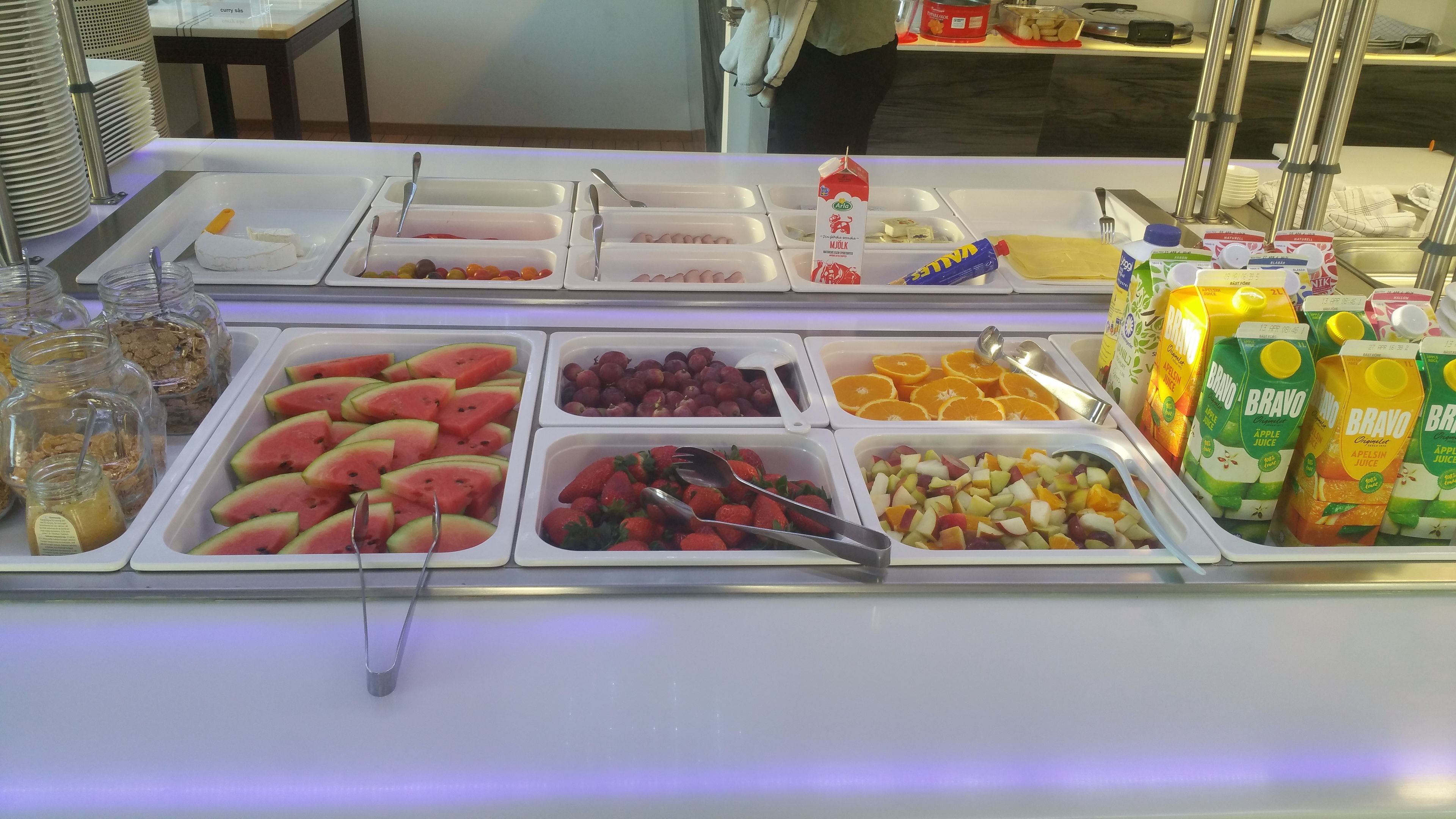 A buffet with various food items including fruits, yogurt, and juices. - Gamleby Hotell (Gamleby)