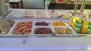 A buffet with various food items including fruits, yogurt, and juices. - Gamleby Hotell (Gamleby)