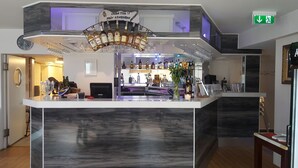 A bar area with a marble countertop, various liquor bottles, and a selection of glasses. - Gamleby Hotell (Gamleby)
