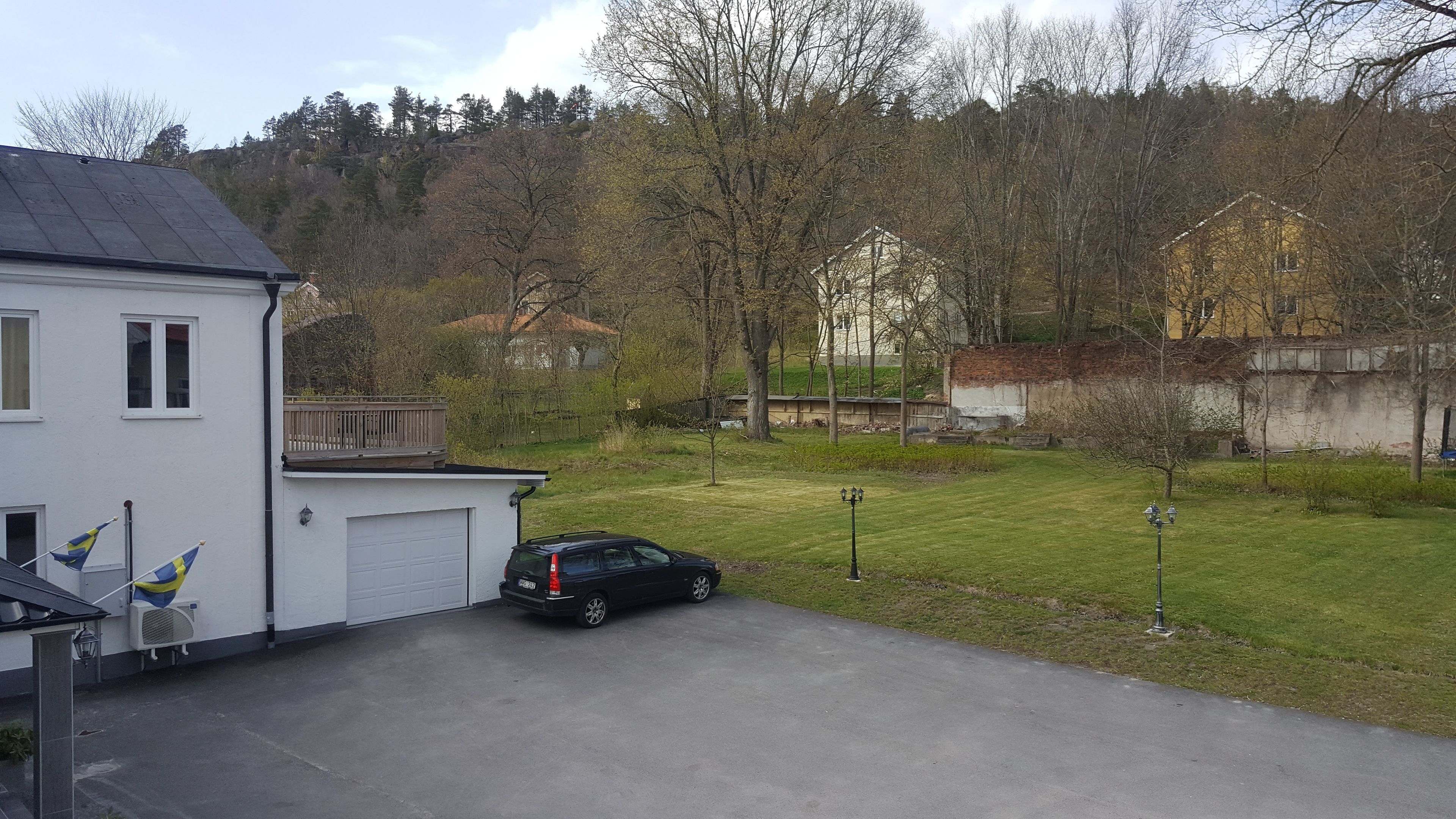 A residential area with a white house, a garage, and a parked car.