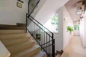 Staircase leads to an upper level with a framed picture and a window.