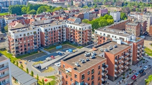 Un immeuble résidentiel de grande hauteur doté de nombreux balcons et d’une cour intérieure.