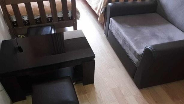 A room with a dark wooden desk, a black leather chair, and a grey sofa. - Apartment on Lermontov Str. (Tbilisi)