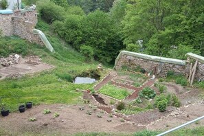 A garden with raised beds, a small pond, and a stone wall. - Castle near Regensburg (Wenzenbach)