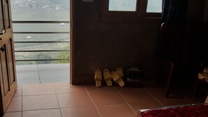 A room with a bed, a window, and a view of a hilly landscape. - Thanh Homestay (Sa Pa)