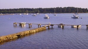 A calm harbor with several boats docked at wooden piers.