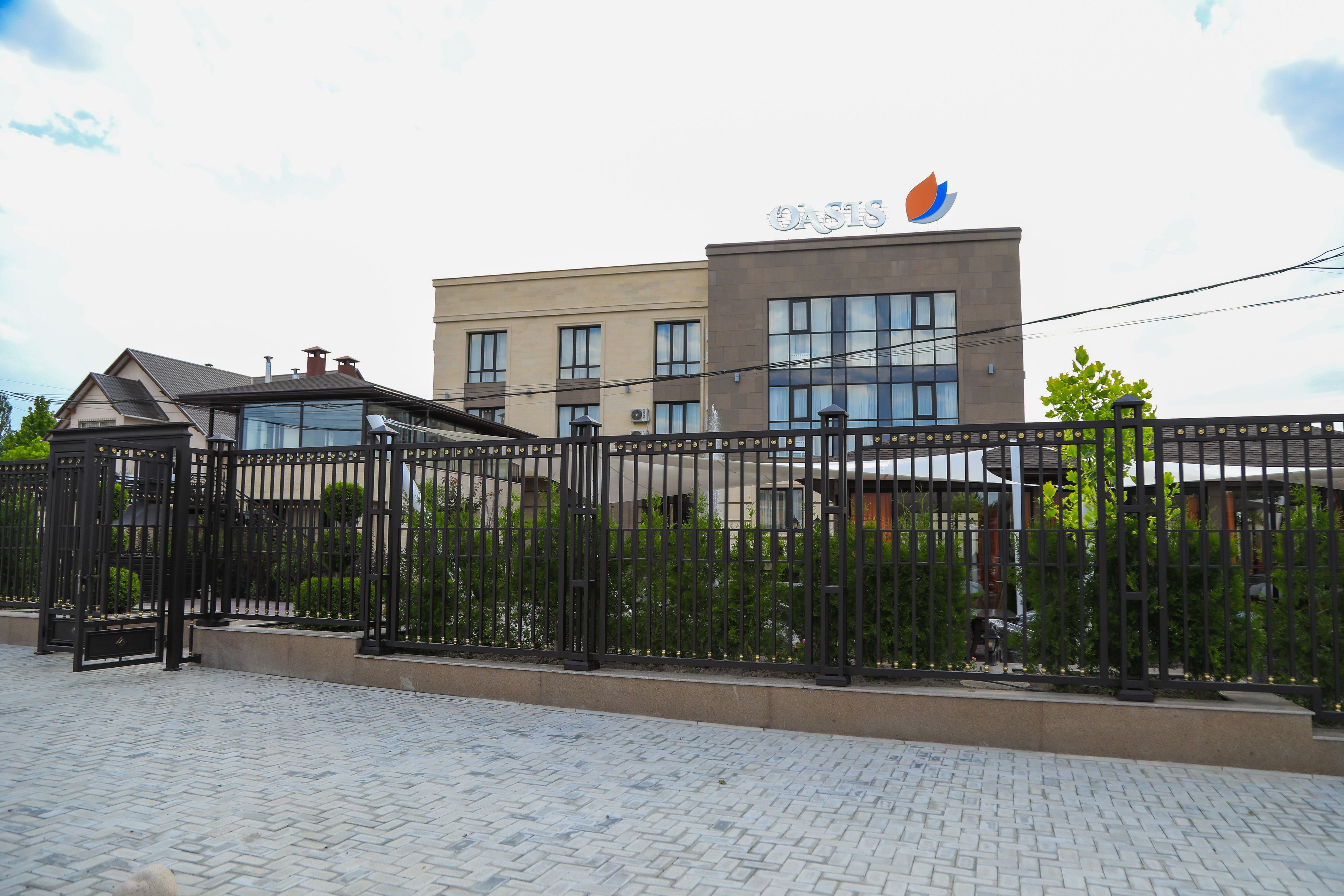 A building with a sign reading "OASIS" and a gated entrance.