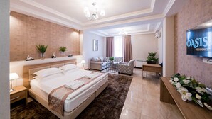 Ein modernes Hotelzimmer mit einem großen Bett, einem Schreibtisch, einer Couch und einem Fernseher.