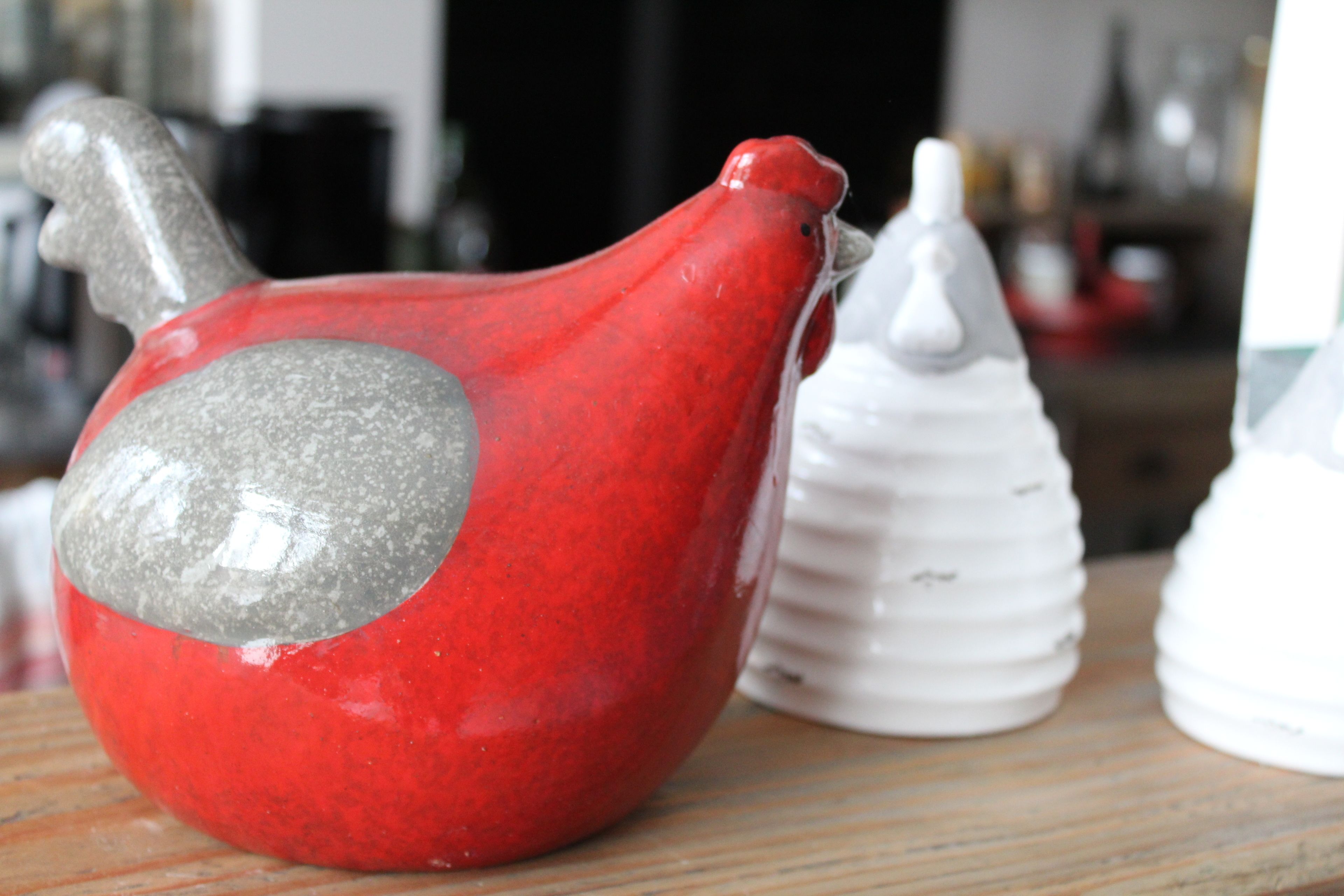 A red ceramic pitcher with a gray patch and a white ceramic container with ridges.