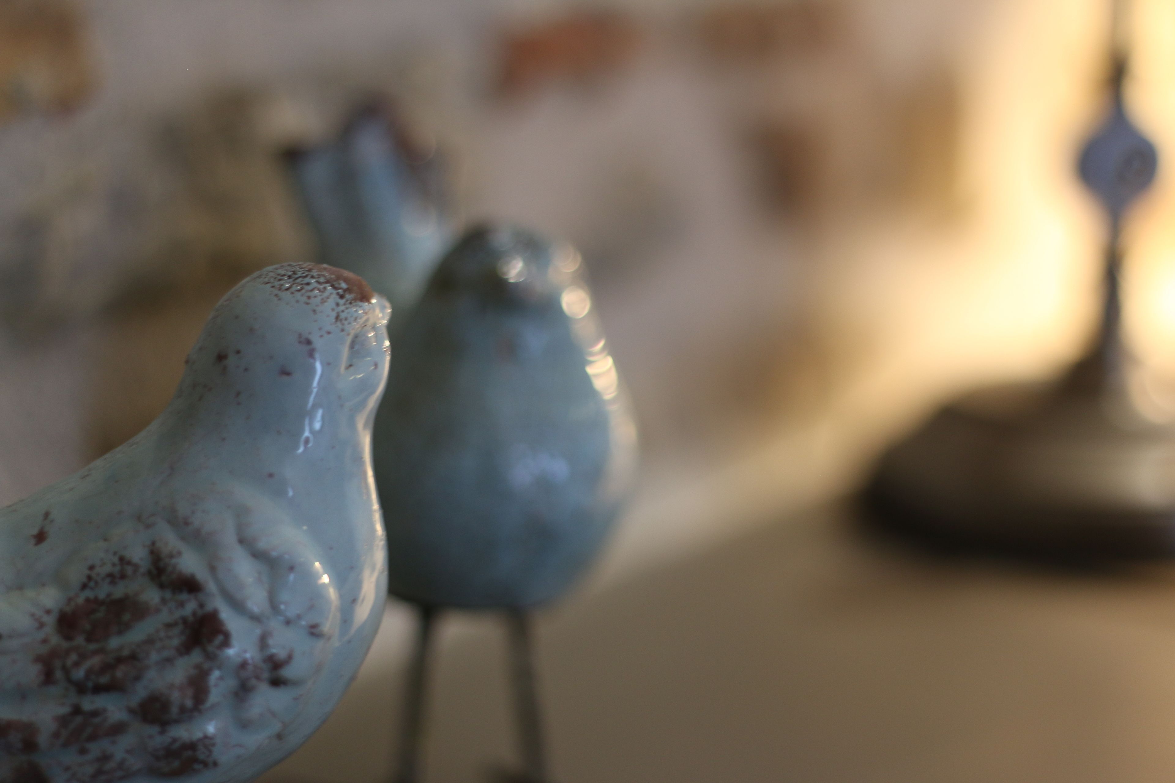 Primer plano de una figurita de pájaro sobre un fondo desenfocado.