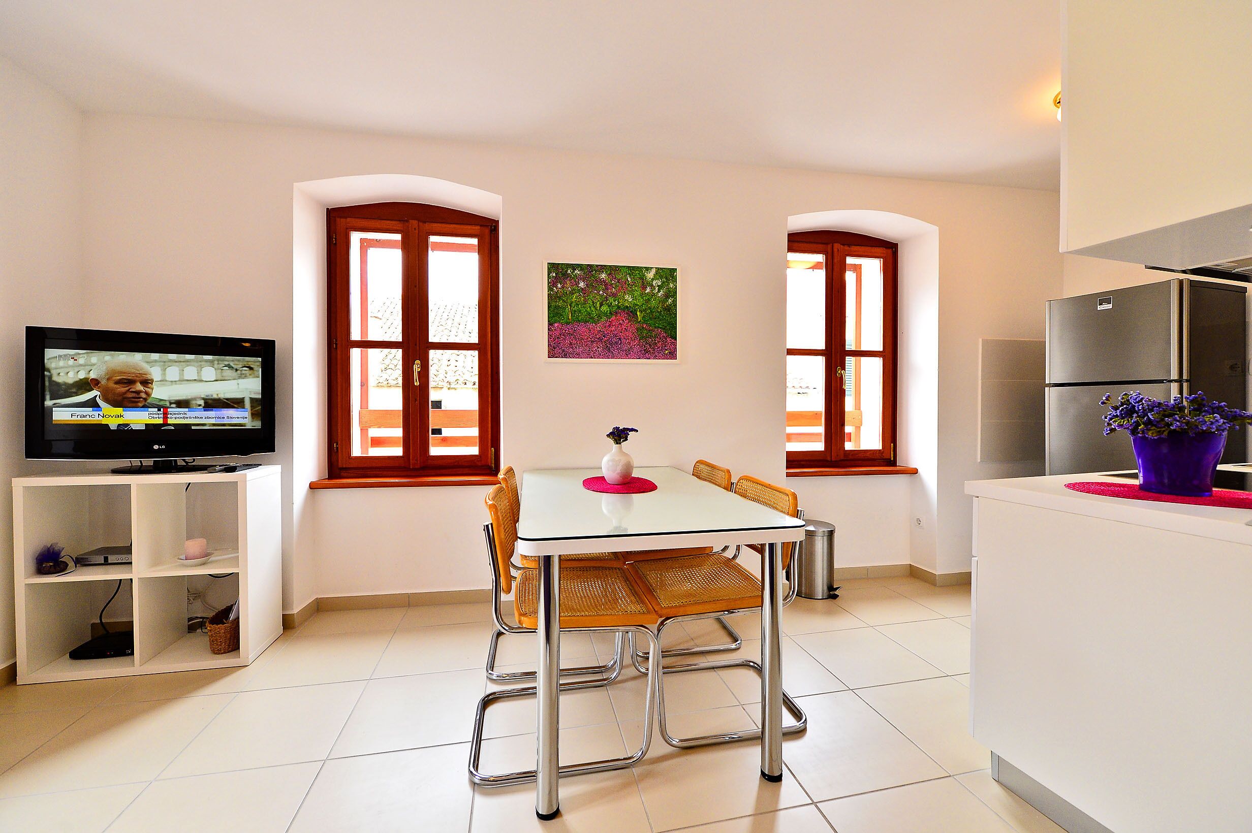 Une cuisine moderne avec un coin repas, un téléviseur et une fenêtre donnant sur un beau paysage.