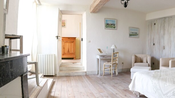 Un dormitorio con cama, escritorio, silla y lámpara.