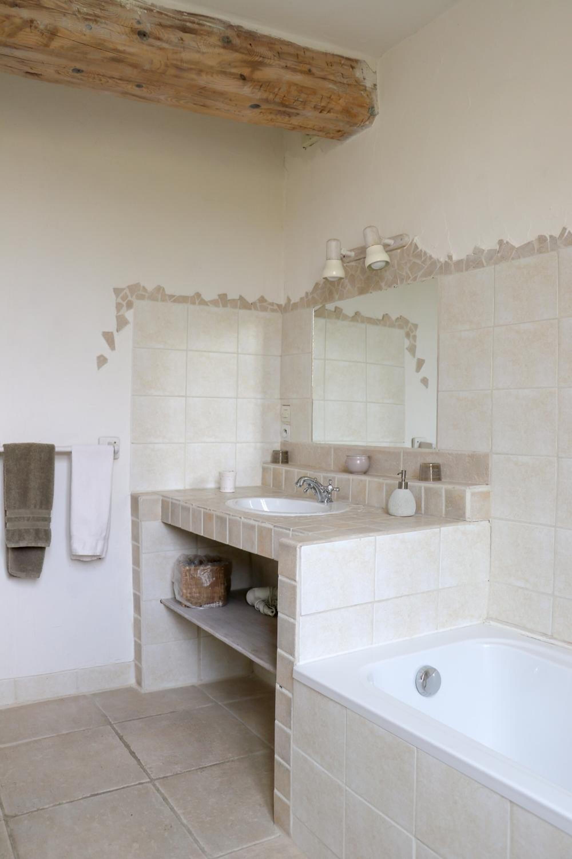 A bathroom with two sinks, a large bathtub, and a mirror above the sink.