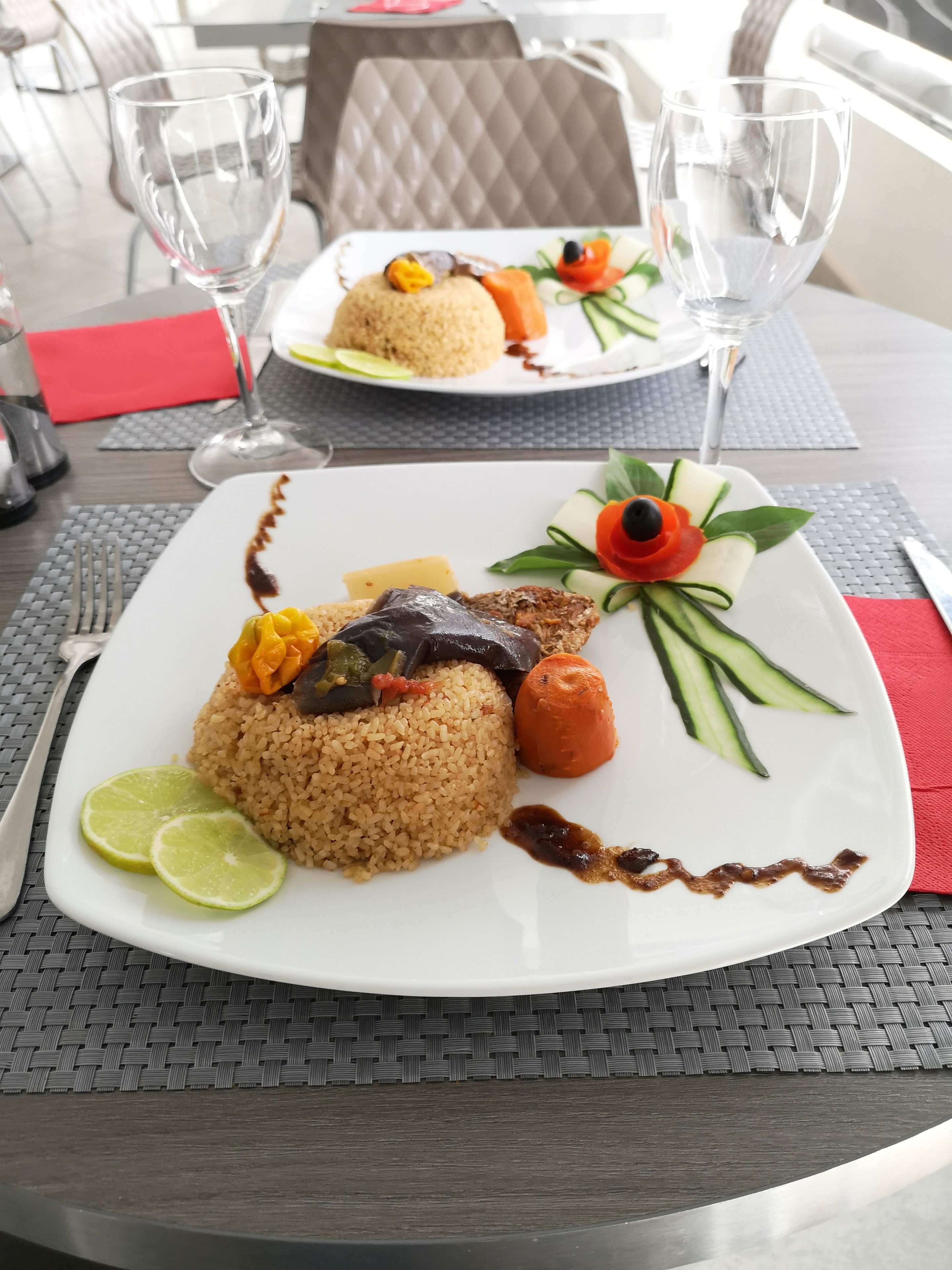A table with a plate of food, a glass of water, and a napkin.