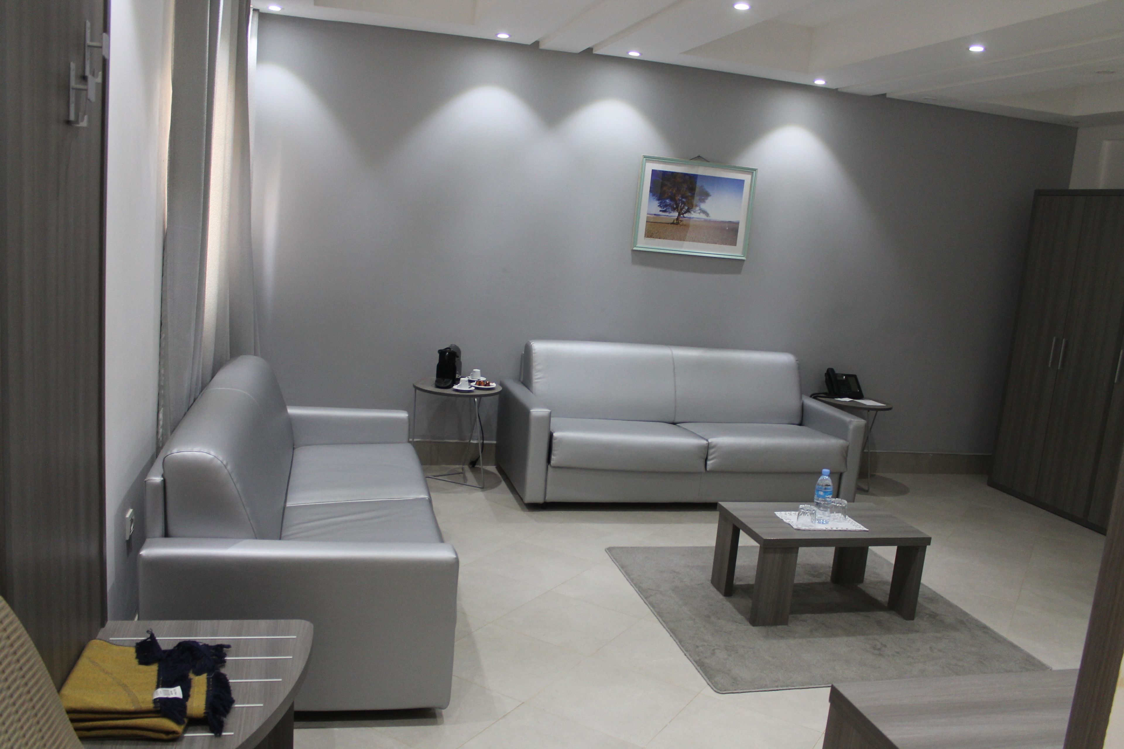 A modern living room with two grey sofas, a coffee table, and a small side table.