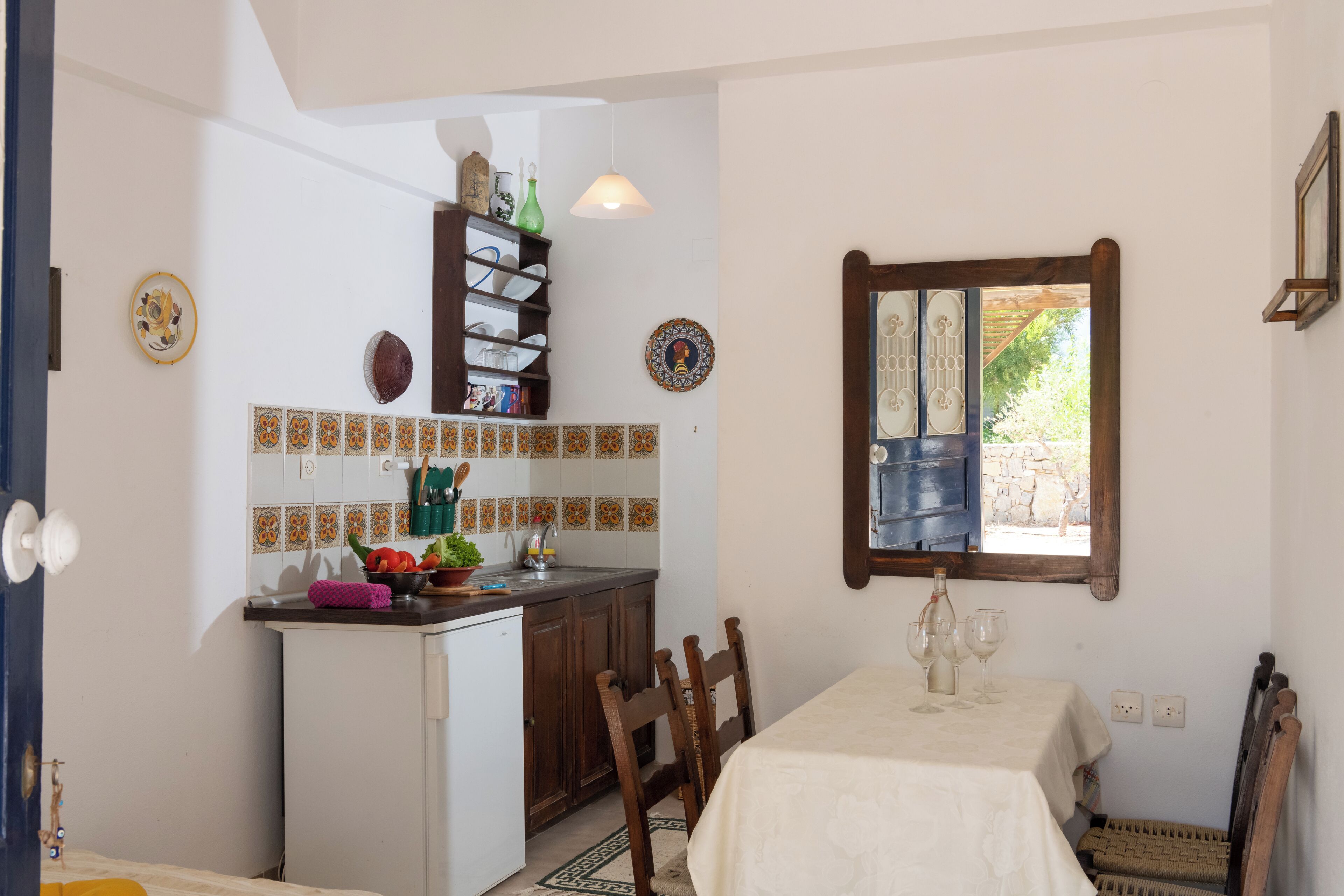 A compact kitchen with a dining area, a window with a view, and a small refrigerator.