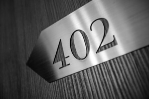 A metallic sign with the number 402. - Hotel Jaime I (Mora de Rubielos)