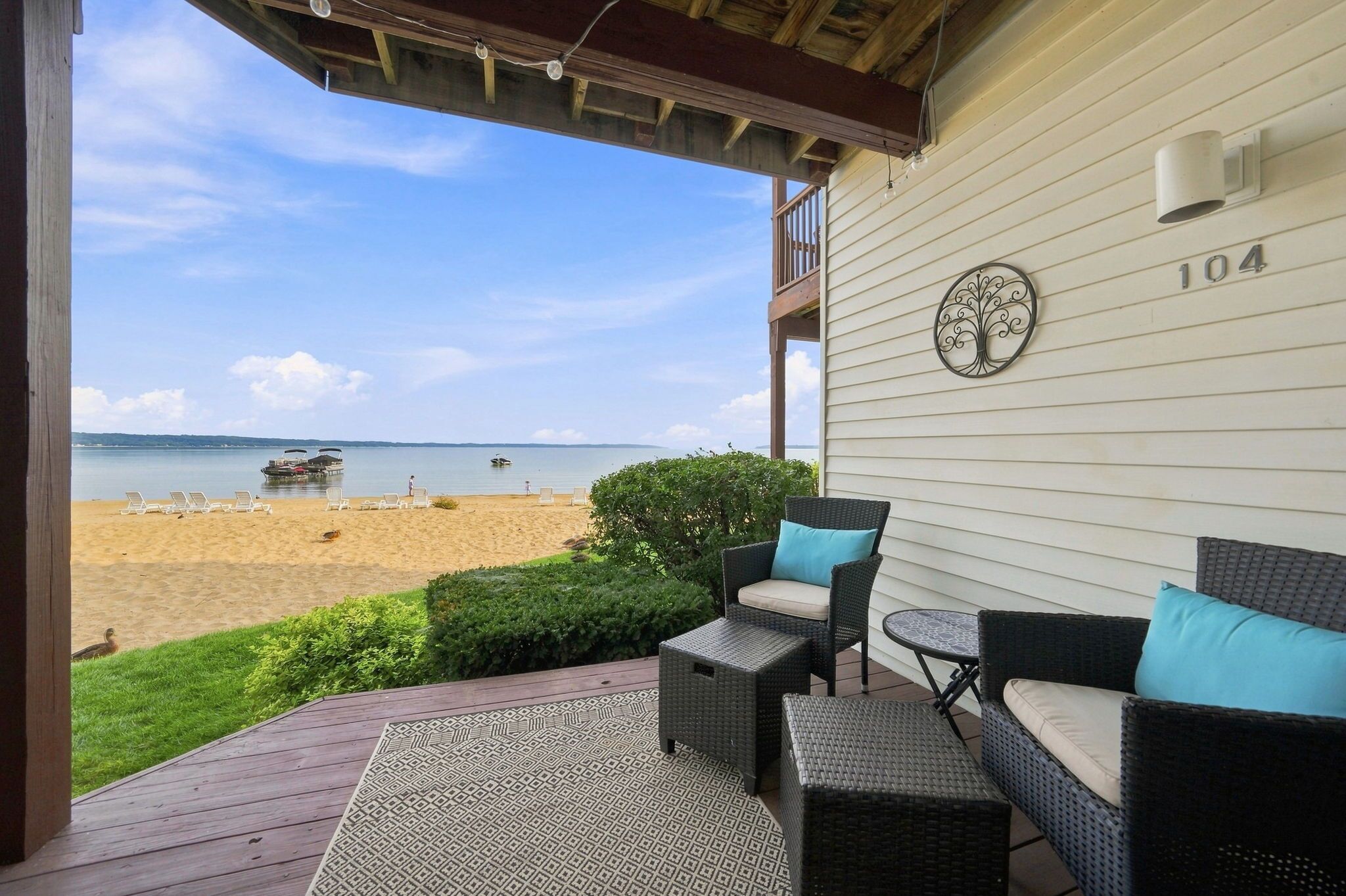 A covered outdoor seating area with wicker furniture and a view of the beach.