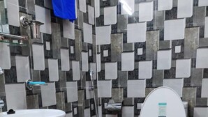 A bathroom with a tiled floor, a sink, a toilet, and a shower. - Asian Heritage Inn & Bistro (Burhanilkantha)