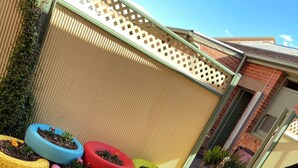 A patio area with colorful tire planters and a wooden barrel stool. - Royal Hotel (Horsham)