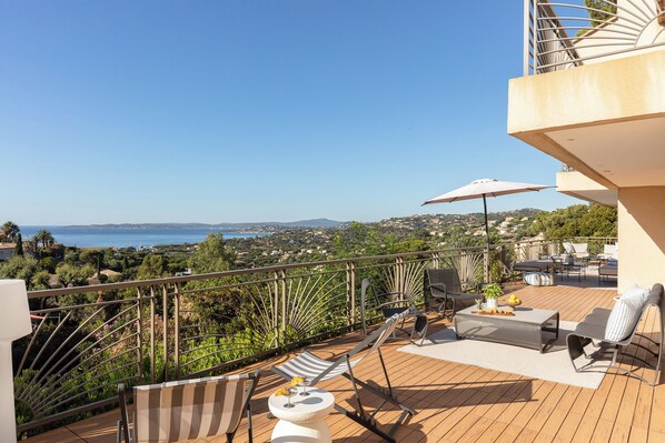 A deck with outdoor furniture, a view of the sea, and a balcony railing. - Villa TourterelleLuxurious villa with breathtaking sea views! (Roquebrune-sur-Argens)