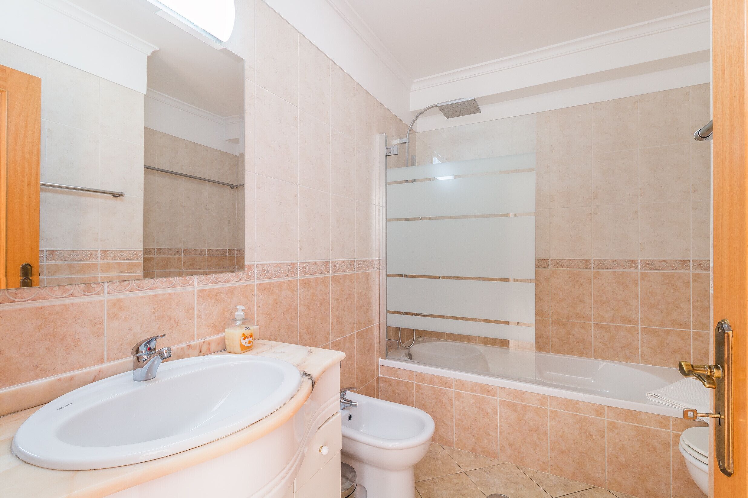 A bathroom with a sink, toilet, bidet, and bathtub.