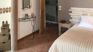 A bedroom with a wooden ceiling, a bed, a bedside table, a mirror, and a wall-mounted shelf. - Bastide Campagne Canal (Cucuron)